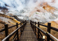 Jigokudani hell valley walking trail, Noboribetsu, Hokkaido, Japan. Selective focus at front banister of wooden footpath.