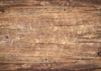 Wood texture background. Surface of old knotted wood with nature color, texture and pattern. Top view of weathered vintage wooden table with cracks. Brown rustic rough wood for backdrop.